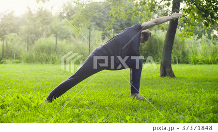 A man doing yoga exercises in the park 37371848