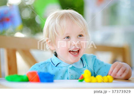 Creative boy playing with colorful modeling clay at kindergarten Creative boy playing with colorful modeling clay at kindergarten 37373929