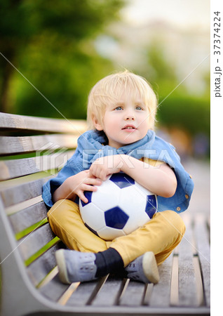 Little boy resting after playing a soccer/football game on summer day 37374224