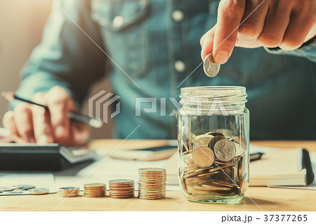 businessman holding coins putting in glass 37377265
