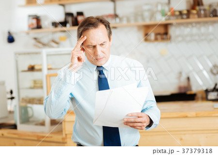 Thoughtful busy man overlooking documents and Thoughtful busy man overlooking documents and 37379318