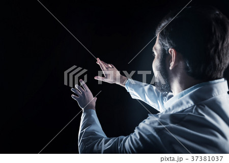 Smart male scientist looking at the virtual screen Smart male scientist looking at the virtual screen 37381037