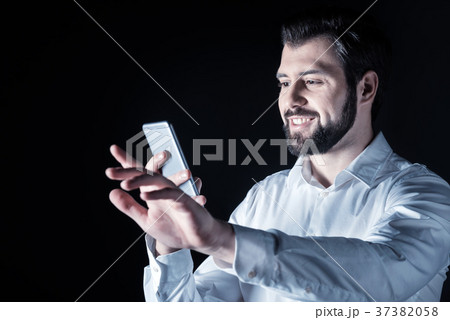 Delighted young man using his device 37382058