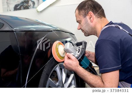 A man polishes a black car A man polishes a black car 37384331