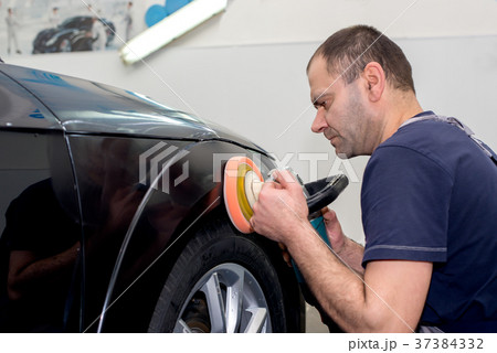 A man polishes a black car 37384332