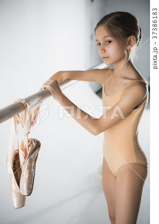 The girl is training near the ballet barre. The girl is training near the ballet barre. 37386183