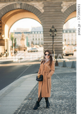 Stylish girl in coat posing for photographer 37386691
