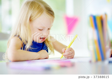 Cute little girl drawing with colorful pencils  37388615