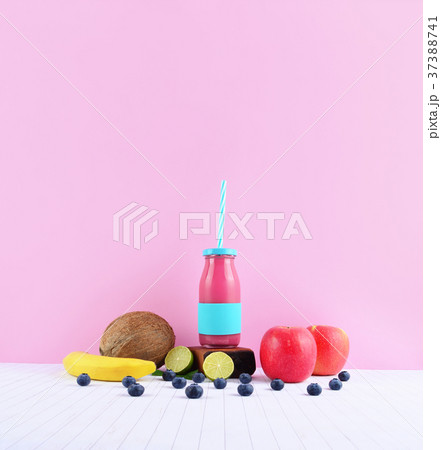 Pink smoothie with tropical fruits on white table. 37388741