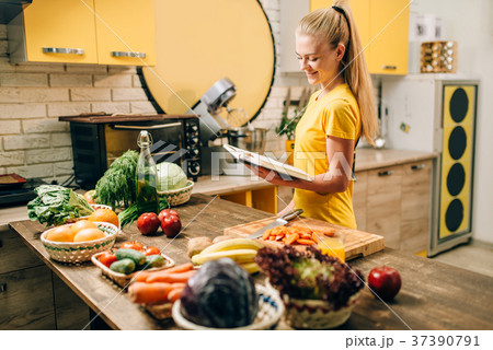 Young woman cooking on recipes, healthy eco food Young woman cooking on recipes, healthy eco food 37390791