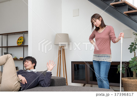 掃除を手伝う様訴える妊娠中の妻とゴロゴロする夫 37396817