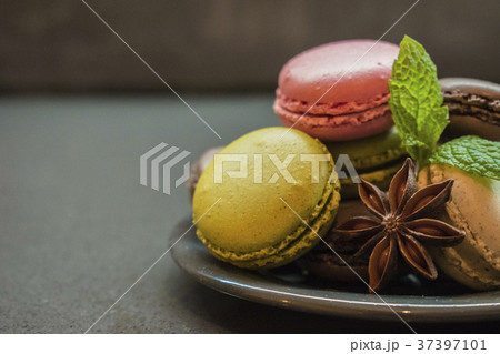 color macaroon cookies on plate, dark background color macaroon cookies on plate, dark background 37397101