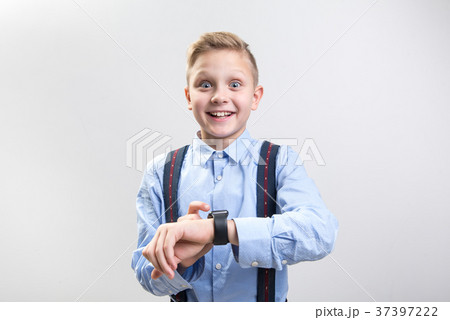 Smiling boy taking delight in new wristwatch Smiling boy taking delight in new wristwatch 37397222