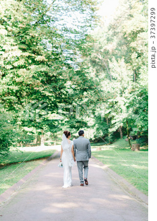 Look from behind at groom and bride walking along Look from behind at groom and bride walking along 37397299