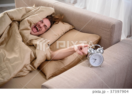 Grumpy man pointing at clock and crying in bedroom Grumpy man pointing at clock and crying in bedroom 37397904