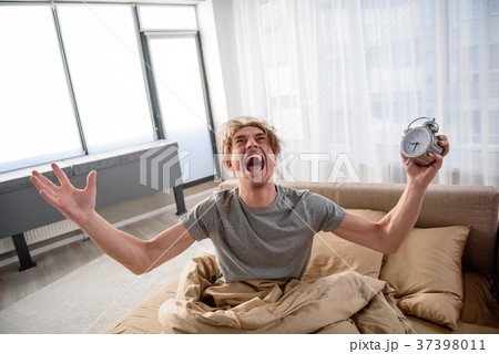 Stressed adult male crying at the alarm at home 37398011