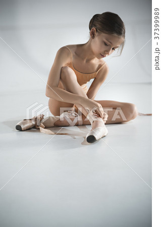 Beautiful little ballerina puting on foot pointe Beautiful little ballerina puting on foot pointe 37399989