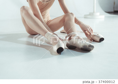 Beautiful little ballerina puting on foot pointe Beautiful little ballerina puting on foot pointe 37400012