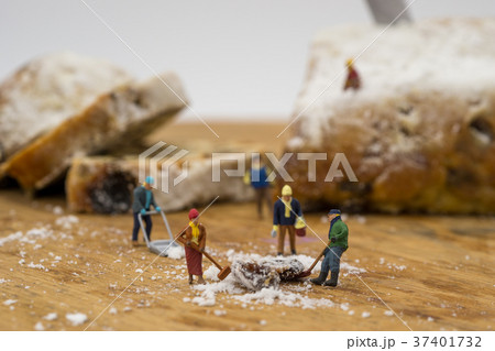 Miniature people shoveling snow from board Miniature people shoveling snow from board 37401732