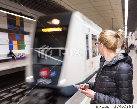 Woman with a cell phone waiting for metro. Woman with a cell phone waiting for metro. 37403361