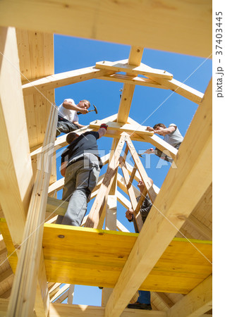 Builders at work with wooden roof construction. Builders at work with wooden roof construction. 37403445