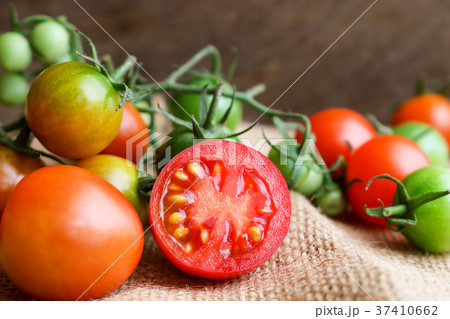 Fresh small tomatoes on wooden background Fresh small tomatoes on wooden background 37410662