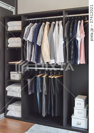 modern closet with cloths hanging in wardrobe modern closet with cloths hanging in wardrobe 37412021
