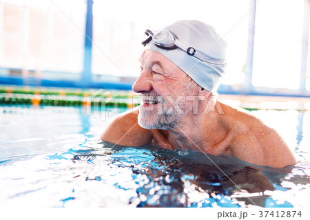 Senior man in an indoor swimming pool. 37412874