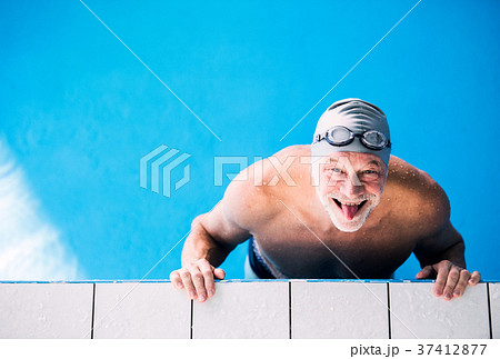 Senior man in an indoor swimming pool. 37412877