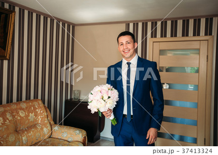 The groom is dressed at home in a suit. Cute groom 37413324
