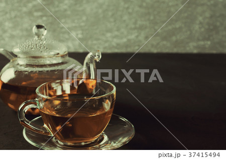 Cup of delicious herbal tea and glass teapot. Cup of delicious herbal tea and glass teapot. 37415494