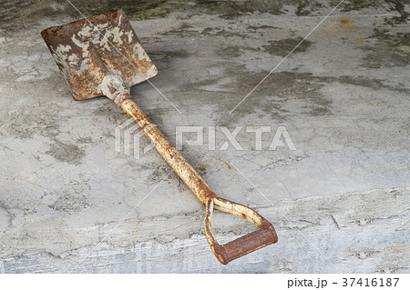 Old rusted shovel on the cement floor. 37416187