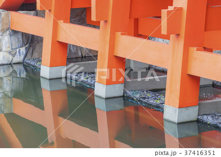 Columns of the red bridge with brook 37416351