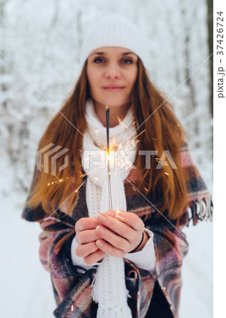 A woman holding a bright festive Christmas spark 37426724