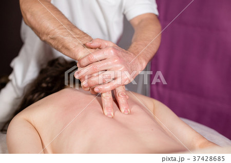 Masseur hands doing spine and back massage, neck Masseur hands doing spine and back massage, neck 37428685