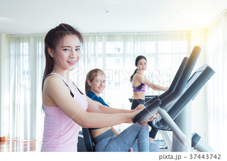 Happy cheerful athletes training on exercise bike. Happy cheerful athletes training on exercise bike. 37443742