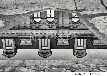 facade of old house reflected in water after rain. facade of old house reflected in water after rain. 37448255