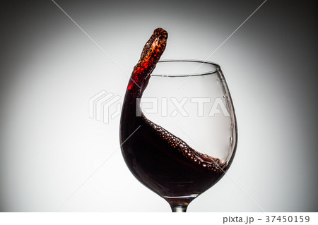 Stream of wine being pouring into a glass. Stream of wine being pouring into a glass. 37450159