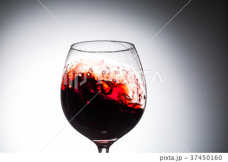 Stream of wine being pouring into a glass. Stream of wine being pouring into a glass. 37450160