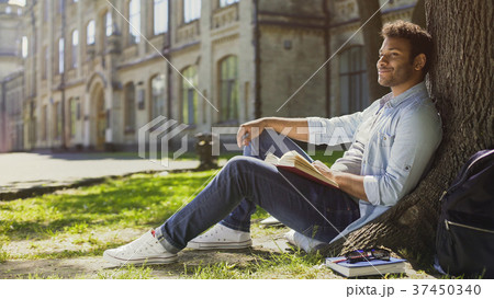 Multiracial guy sitting under tree, looking and 37450340