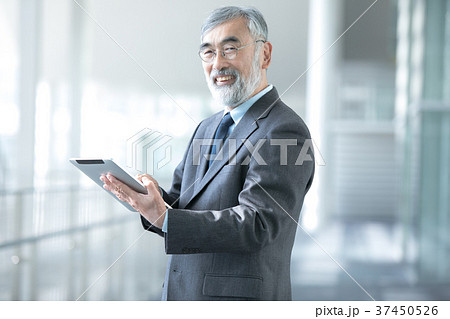 タブレット端末を使うビジネスマン　社長　幹部社員　ビジネスイメージ 37450526
