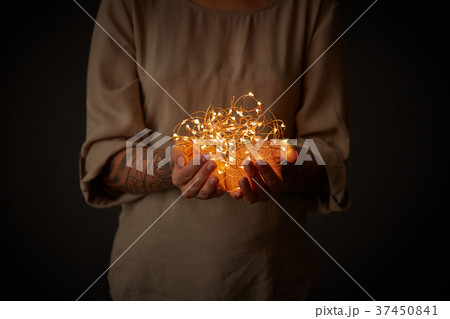 Christmas lights garland in female hands 37450841