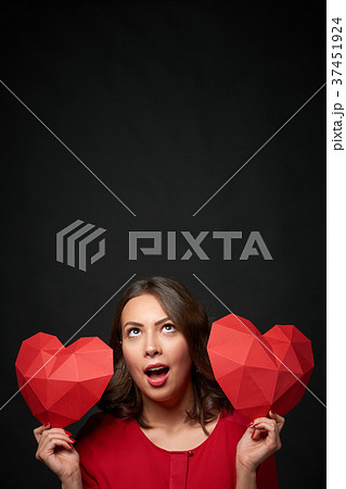 Smiling woman holding two polygonal heart shape 37451924