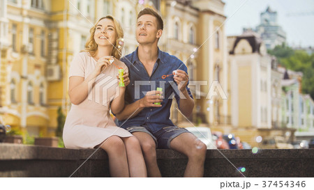 Cheerful carefree blowing bubbles and enjoying 37454346