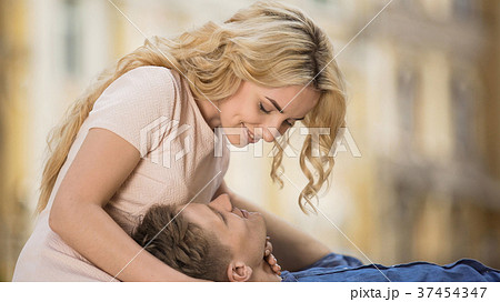 Male holding head on girls lap, girlfriend hugging 37454347
