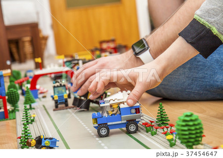 Father and son playing with plastic blocks 37454647