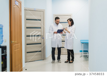 Two doctors discussing diagnosis while walking 37458033