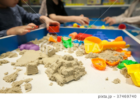 Kids playing plastic mold toy with sand on sandbox 37469740