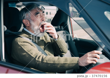 運転中にあくびをするシニア男性 高齢運転者 運転中にあくびをするシニア男性 高齢運転者 37470156