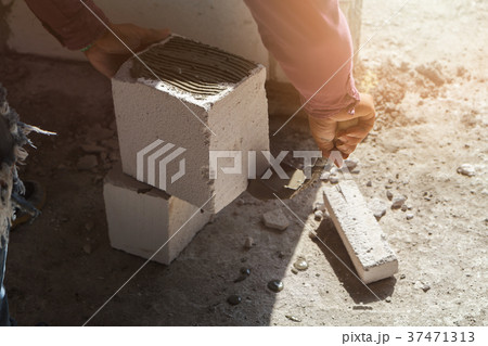 Bricklayer plastering cement on brick. 37471313